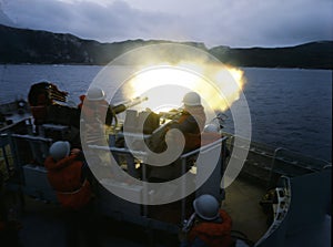 Argentinian warship fire cannon with 2 soldiers off the coast of the Falkland Islands April 82, warship, battle shot