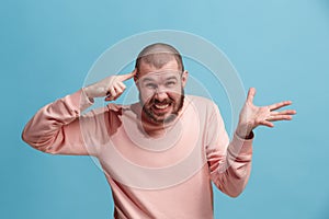 Beautiful male half-length portrait isolated on blue studio backgroud. The young emotional surprised man