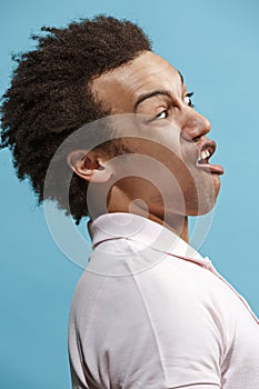 Beautiful male half-length portrait isolated on blue studio backgroud. The young emotional surprised man