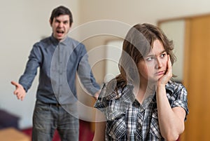 Argue of young couple. Angry man is arguing and sad woman is ignoring him