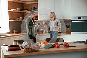 Arguing, yelling at each other. Young couple is on the kitchen together