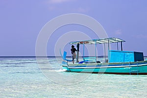 Ari Atoll, Maldives: A maldivian sailor is fishing on his boat