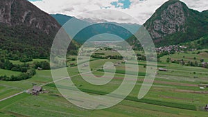 Arial panorama of wide farm fields surrounded by mountains