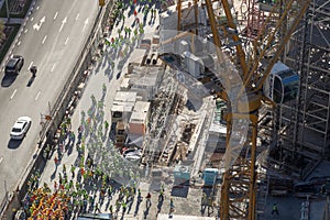 Arial view of a big group of construction workers, grouped on side of the road
