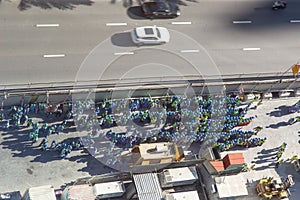 Arial view of a big group of construction workers, grouped on side of the road