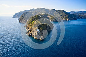 Arial view on the mountain range with a white lighthouse near Ligurian sea on the foreground. Tradition colorful italian houses
