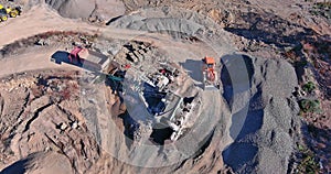 Arial view of the open pit mine gravel into stone crusher in heavy mining machinery equipment for earthworks