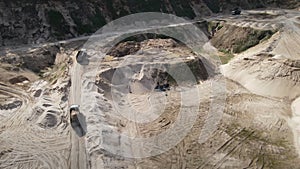 Arial view of the opencast mine. Dump truck transported sand from the open pit. Truck with tipper semi trailer working in quarry.
