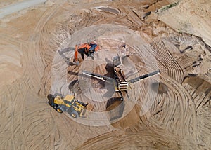 Arial view of the sand open-pit mining with heavy mining machinery. Mobile stone jaw crusher machine in open pit mine. Wheel