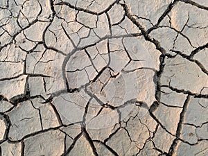 Arid and barren land caused with hot weather and drought, erosion and crack ground, abstract mosaic pattern