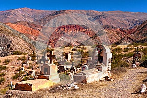 Arid and colorful landscape, with mountains and rural graves in the foreground