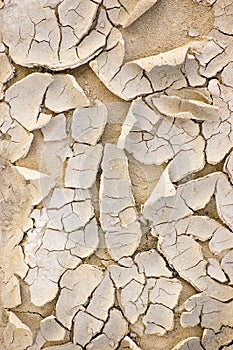 Arid cracked desert like river bed ground texture after a drought large detailed textured vertical macro closeup pattern