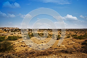 Arid landscape with town in background, Jaisalme