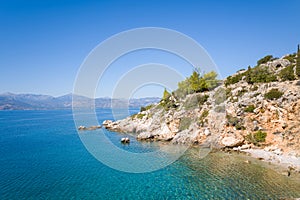 The arid rocky coast and its green countryside along small beaches, in Europe, Greece, Peloponnese, Argolis, Nafplio, Myrto