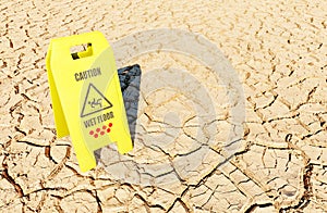 arid terrain with a caution sign for wet floor
