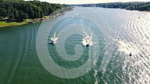 An Ariel dolly of 3 boats in a head on POV with wakes spreading and crossing behind them on a recreational Reservoir Lake