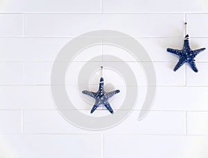 Aritificial starfishes ornamental hanging on bricks wall for decoration in the room.