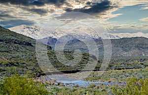 Arizona desert landscape with saguaro cactus at sunset with snow covered mountains