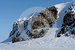 Arktic. Cliffs protruding from the snow.