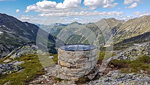 Arlhoehe - A pile of stones with a map on top in high Alps