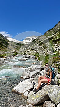 Arlhoehe - A woman enjoying a cascading waterfall in the Alps