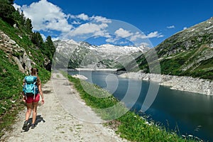 Arlhoehe - A woman in shorts hiking along a lake in Alps