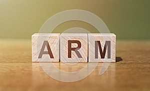 ARM Advanced RISC Machines word written on wooden blocks on wooden table. Concept for your design