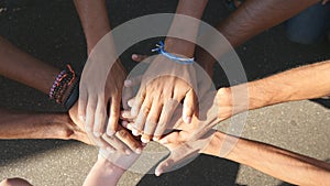 Arm of all races and colors stacked together one by one in unity and teamwork and then raised. Many multiracial hands