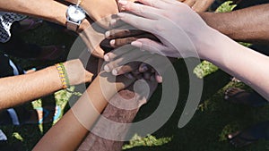 Arm of all races and colors stacked together one by one in unity and teamwork and then raised. Many multiracial hands