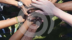 Arm of all races and colors stacked together one by one in unity and teamwork and then raised. Many multiracial hands photo