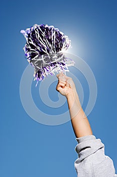 Arm of a cheerleader holding pom-pom