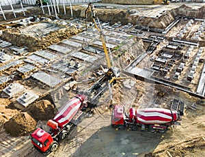 Arm of concrete pump ready for concrete conveying at construction site. Jib of concrete pump truck against sky at background.