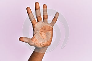 Arm and hand of black middle age woman over pink isolated background counting number 5 showing five fingers