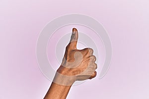 Arm and hand of black middle age woman over pink isolated background doing successful approval gesture with thumbs up, validation