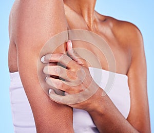 Arm injury, stress and hands of woman in studio with arthritis, osteoporosis or emergency on blue background. Shoulder