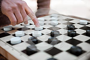 Arm of man pushing chequer on board