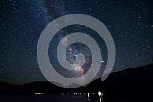 Arm of Milky Way galaxy visible over mountain lake