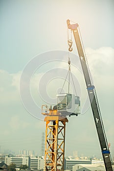 Arm of mobile construction crane is Installing yellow construction tower crane