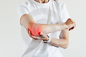 Arm pain and injury for woman. Closeup side body with painful elbow isolated on beige background