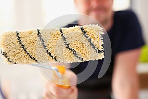 Arm of smiling worker hold brush closeup