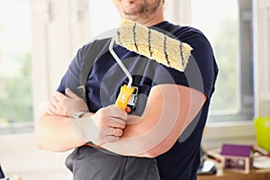 Arm of smiling worker hold brush closeup