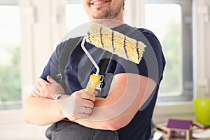 Arm of smiling worker hold brush closeup