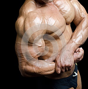 Arm and torso of muscular male bodybuilder flexing biceps