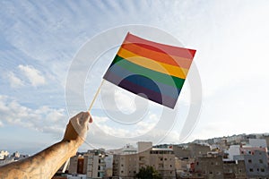 Arm waving and holding pride rainbow flag, support LGBTQ community. Sexual identity for equal social discrimination for freedom of