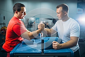 Arm wrestlers prepares for battle at the table