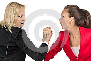 Arm wrestling of two smiling businesswoman