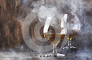 Armagnac, French grape brandy, strong alcoholic drink. Still life in vintage style with cigar smoke, copy space