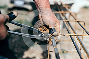 Armature bars in construction site, hands of builder man, construction worker on site