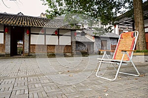 Armchair on brick-paved ground before houses in ancient town