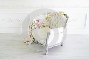 Armchair in white room. Beautiful interior, decorated with flowers. Toning in the style of instagram